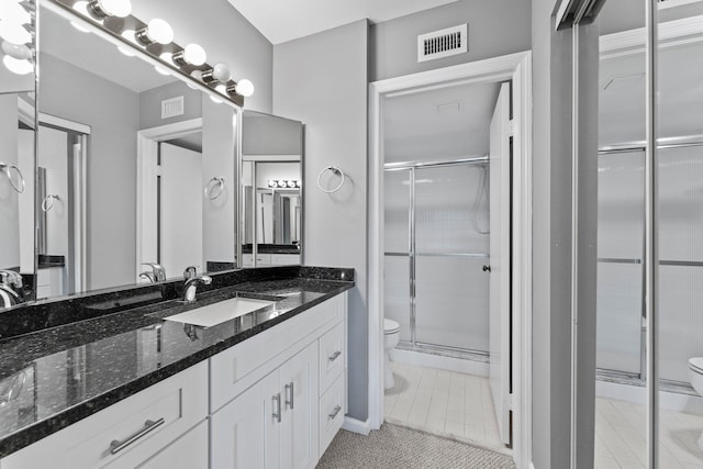 bathroom featuring vanity, toilet, and a shower with door