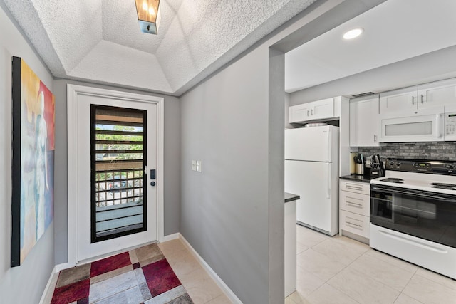 tiled entryway featuring a tray ceiling