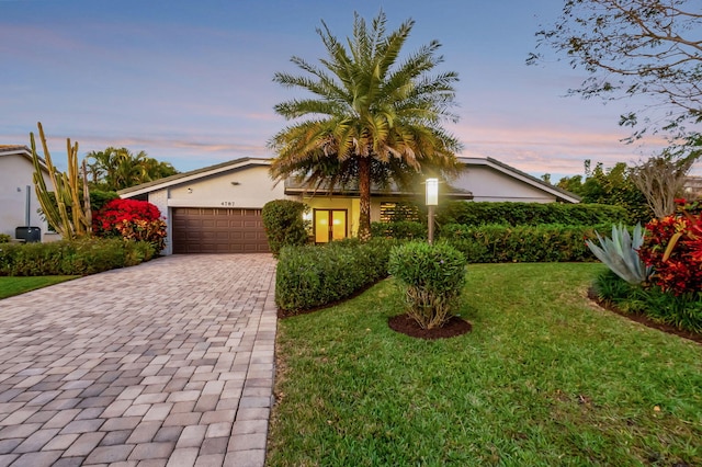 view of front facade featuring a garage and a lawn