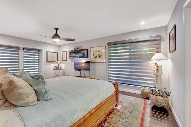 bedroom featuring ceiling fan, multiple windows, and hardwood / wood-style floors