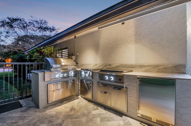 patio terrace at dusk featuring grilling area and area for grilling