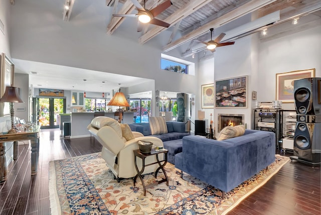 living room with beam ceiling, french doors, a towering ceiling, and hardwood / wood-style floors