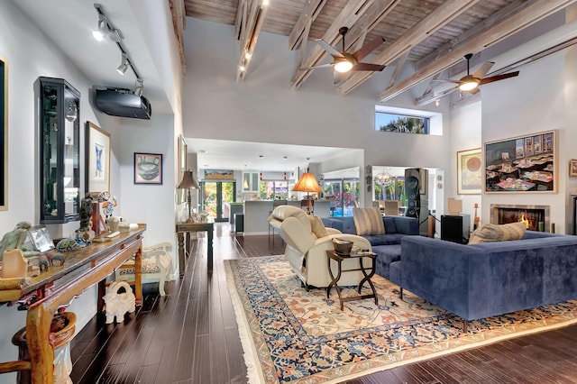 living room featuring ceiling fan, beamed ceiling, track lighting, dark hardwood / wood-style flooring, and wooden ceiling