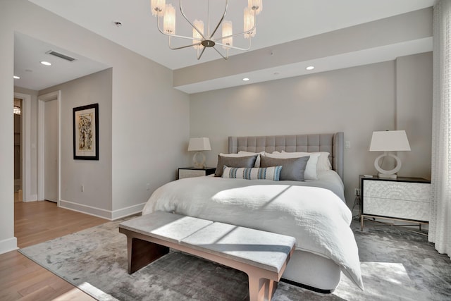 bedroom with a chandelier and light hardwood / wood-style floors