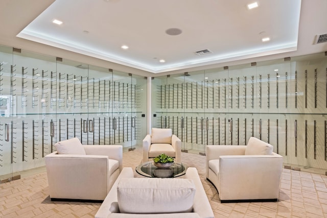 living area with a mail area and a tray ceiling