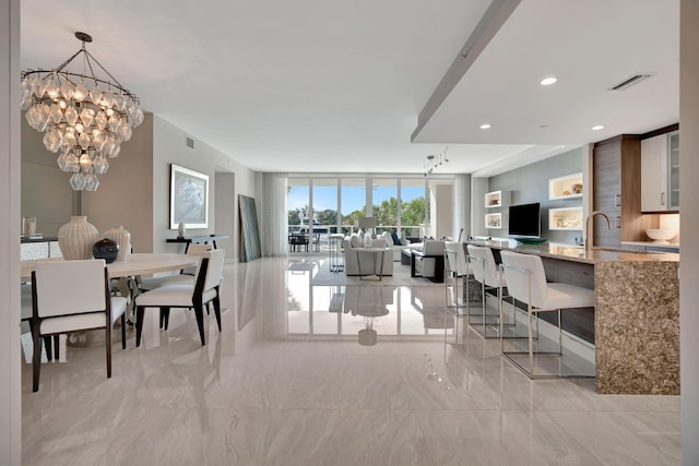 interior space featuring a notable chandelier, expansive windows, and sink