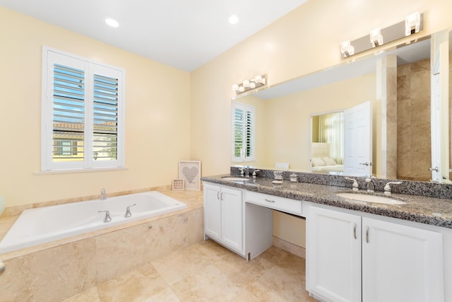 bathroom with a relaxing tiled tub and vanity