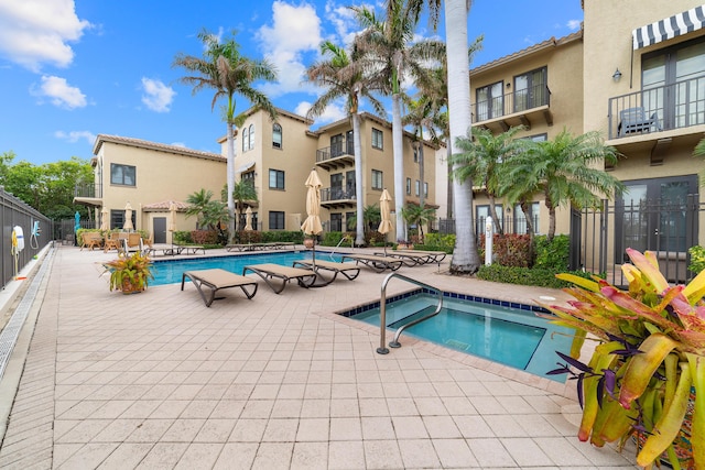 view of swimming pool featuring a community hot tub and a patio area