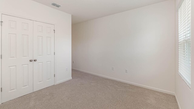 unfurnished room featuring light colored carpet