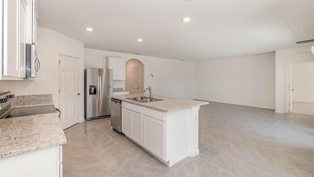 kitchen with a center island with sink, white cabinets, sink, and stainless steel appliances