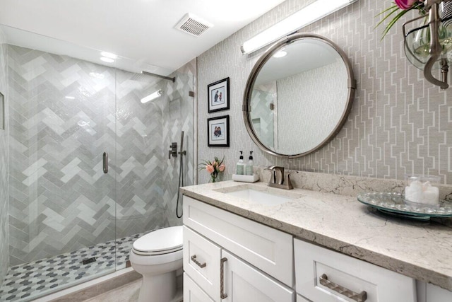 bathroom with tile patterned floors, vanity, toilet, and a shower with door