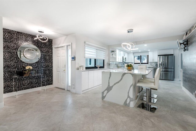 kitchen featuring a notable chandelier, white cabinets, decorative light fixtures, and appliances with stainless steel finishes