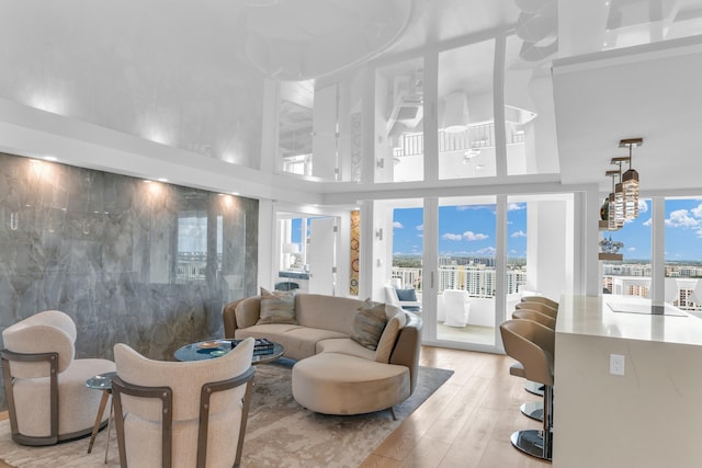 living room featuring a towering ceiling and light hardwood / wood-style floors