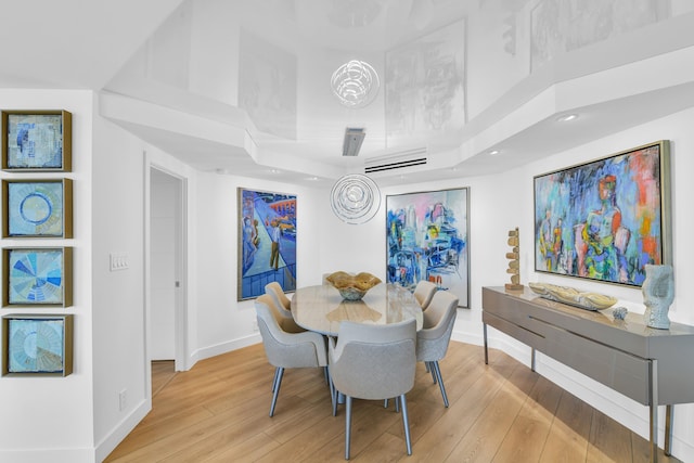 dining room featuring light hardwood / wood-style flooring and a high ceiling