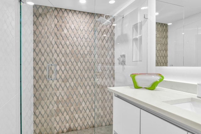 bathroom featuring a tile shower and vanity