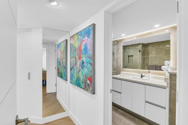 bathroom with a shower with door, vanity, and hardwood / wood-style floors