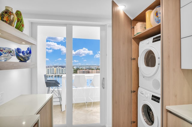 clothes washing area featuring stacked washer and clothes dryer