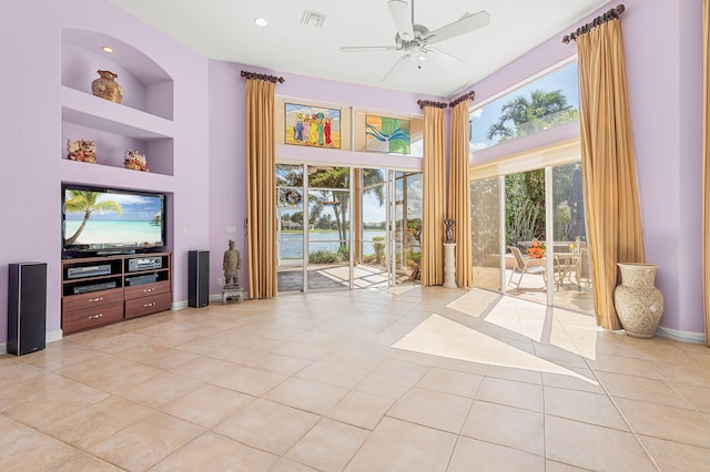 entryway featuring a high ceiling, light tile patterned floors, ceiling fan, and built in shelves