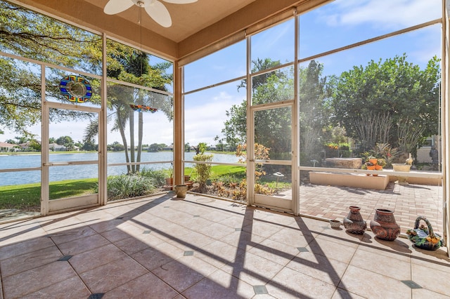 unfurnished sunroom featuring a water view and ceiling fan