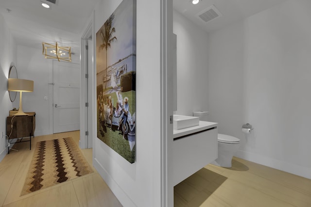 bathroom featuring hardwood / wood-style flooring, vanity, and toilet