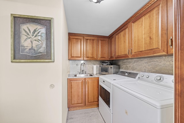 laundry room with washer and dryer, light tile patterned flooring, sink, and cabinets