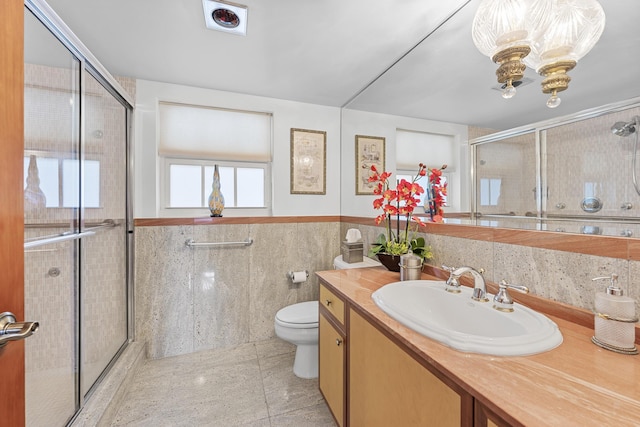 bathroom featuring walk in shower, vanity, toilet, and tile walls