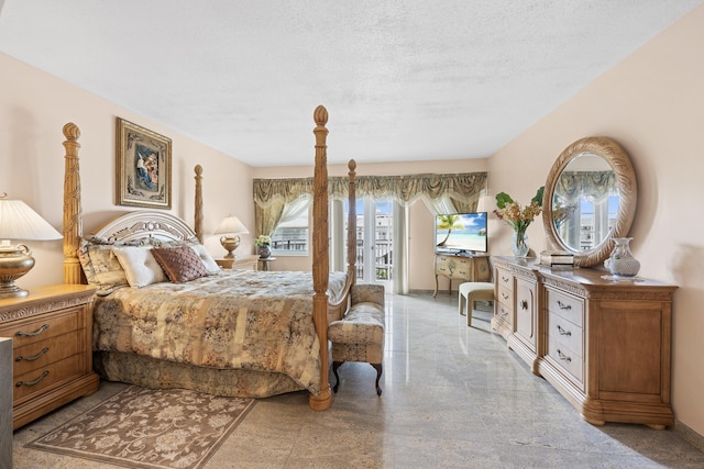 bedroom with access to exterior and a textured ceiling