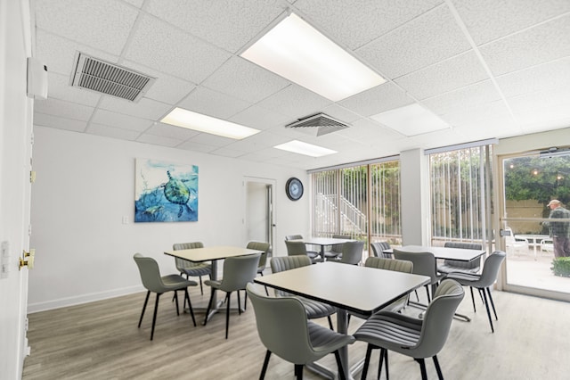 dining space featuring hardwood / wood-style flooring and a drop ceiling