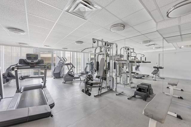 gym featuring a wall of windows and a paneled ceiling