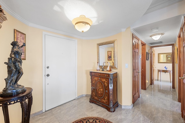 entrance foyer featuring ornamental molding and a textured ceiling