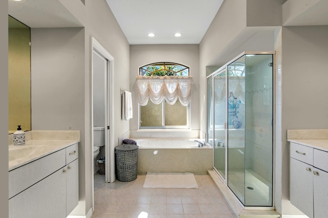 full bathroom featuring separate shower and tub, vanity, and toilet