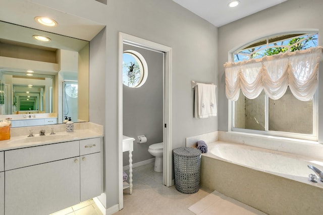 bathroom featuring tile patterned flooring, vanity, toilet, and a bathing tub