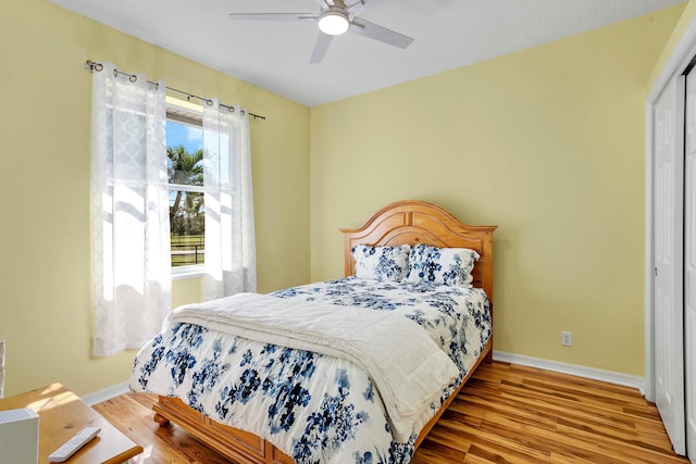 bedroom with ceiling fan, wood-type flooring, and a closet