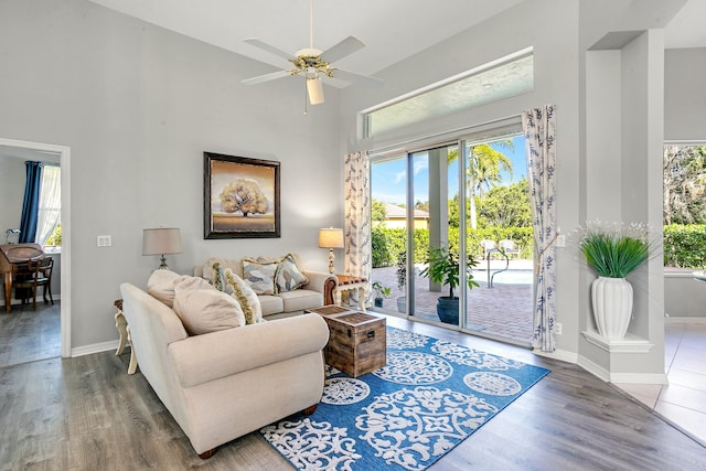 living room with ceiling fan, a high ceiling, and hardwood / wood-style flooring