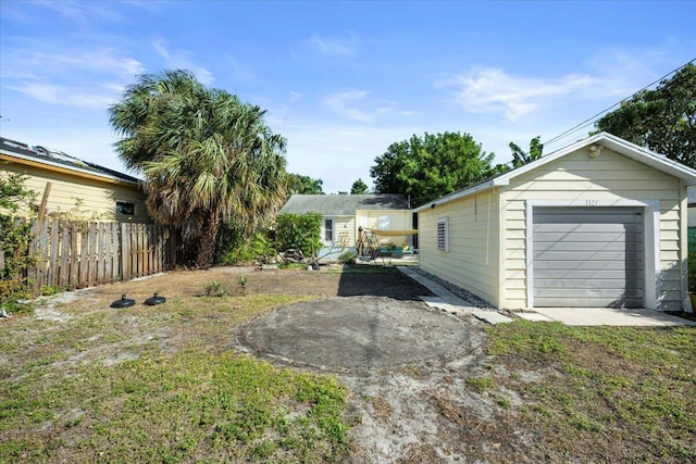 view of yard featuring a garage and an outbuilding