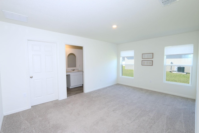 interior space with light carpet and ensuite bath