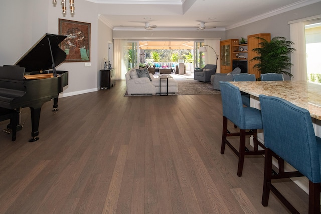 dining area with dark wood-type flooring, ceiling fan, and crown molding