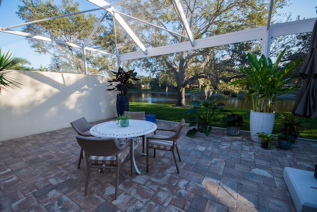 view of patio / terrace featuring glass enclosure and a water view