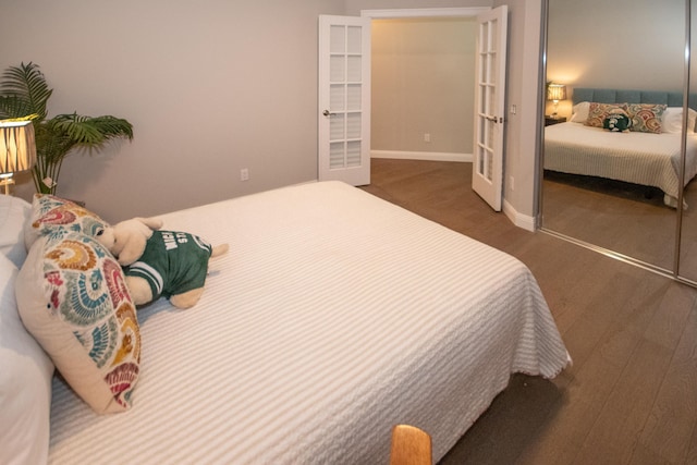 bedroom with a closet, dark wood-type flooring, and french doors