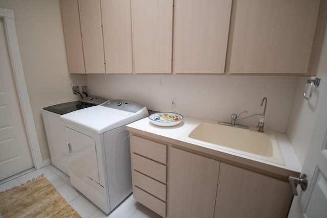 laundry room with washer and dryer, sink, light tile patterned floors, and cabinets