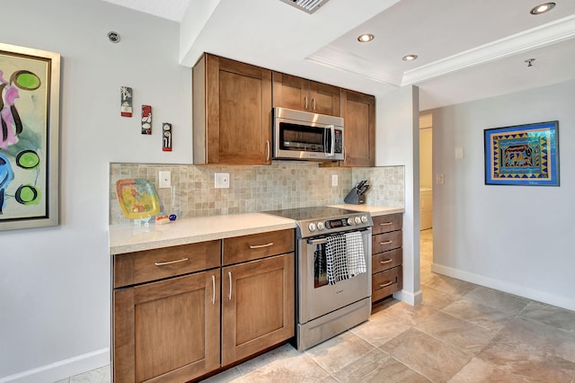 kitchen featuring decorative backsplash, ornamental molding, stainless steel appliances, and a tray ceiling