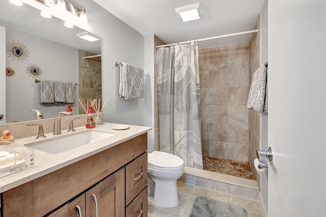 bathroom featuring tile patterned floors, vanity, toilet, and curtained shower