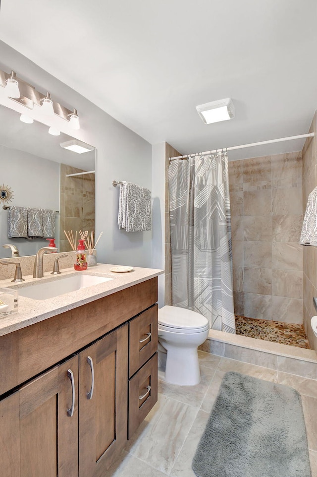 bathroom with tile patterned floors, vanity, curtained shower, and toilet