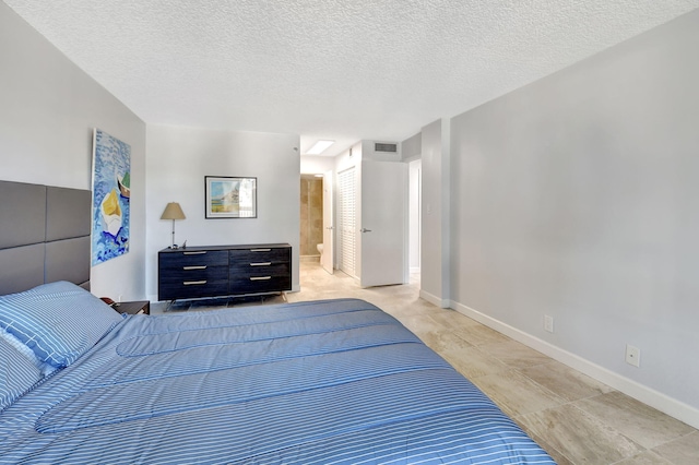 bedroom featuring a textured ceiling and connected bathroom