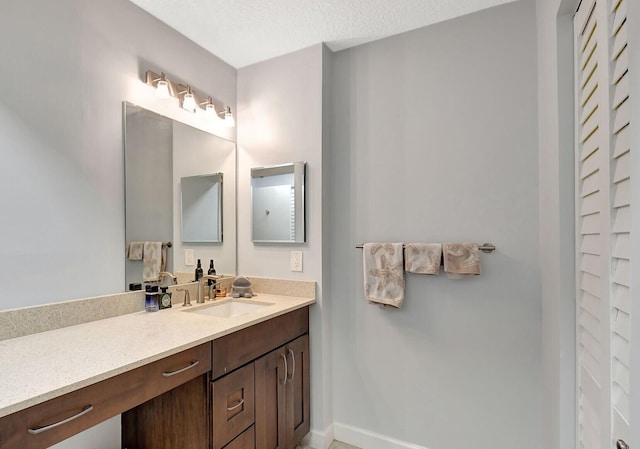 bathroom featuring a textured ceiling and vanity