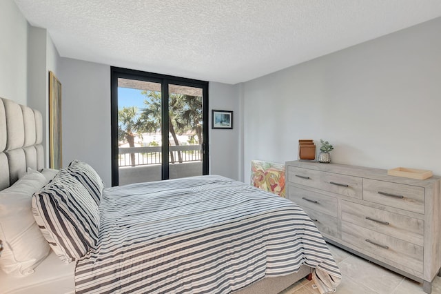 bedroom featuring access to exterior and a textured ceiling