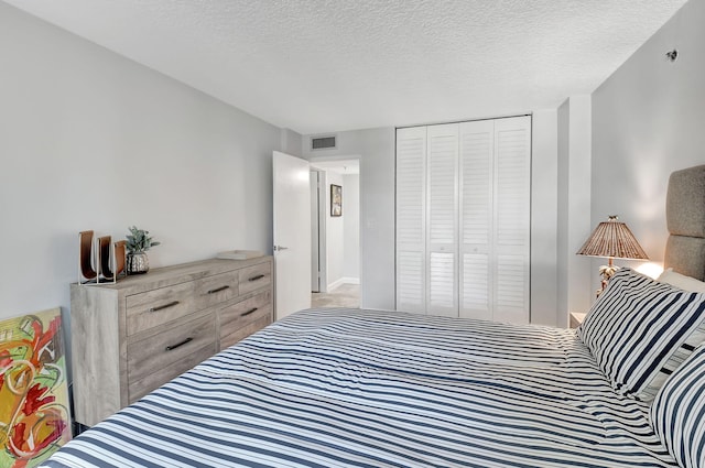 bedroom with a textured ceiling and a closet