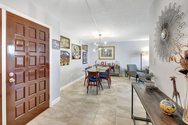 dining area featuring a notable chandelier and a textured ceiling