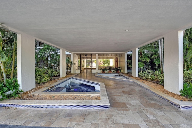 view of pool featuring an in ground hot tub and a patio