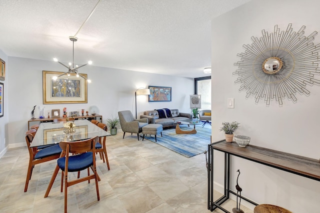 dining area with a textured ceiling and a notable chandelier